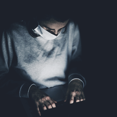 Person with medical mask in front of laptop