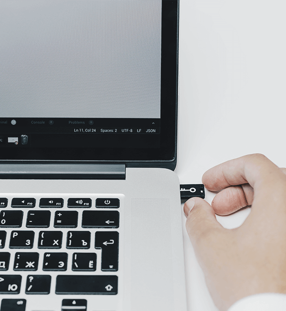 Person die einen Microchip in einen Laptop steckt mit einem Schlüssel darauf abgebildet