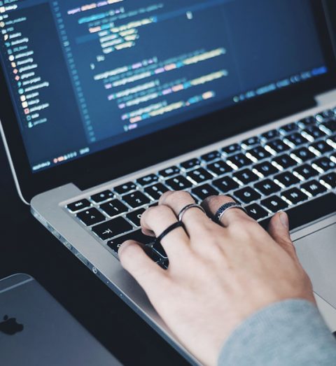 Person working on a laptop with code on the screen