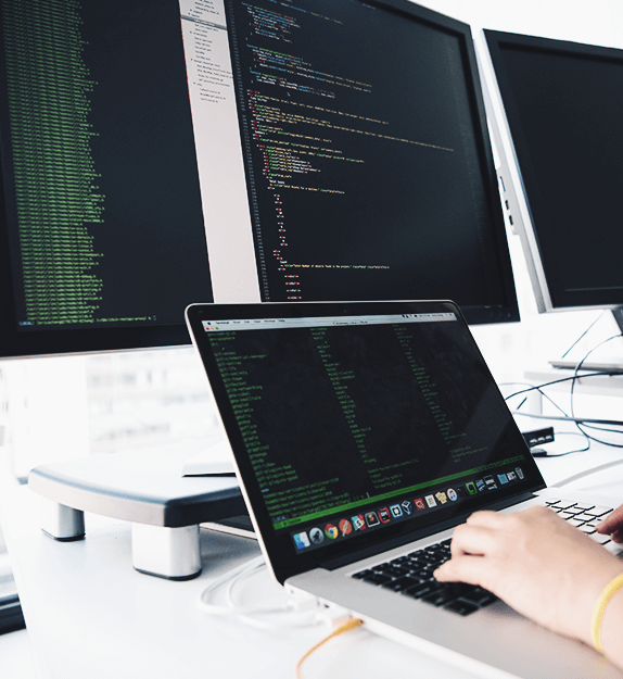 Person arbeitet an einem Laptop mit Code auf dem Bildschirm