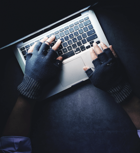 Hand typing on a laptop keyboard