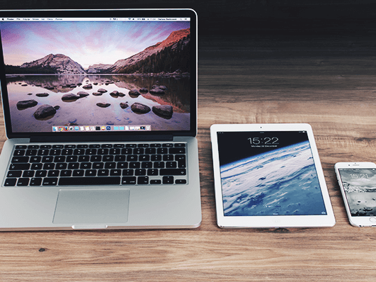 Laptop, tablet and cell phone lie side by side on a table