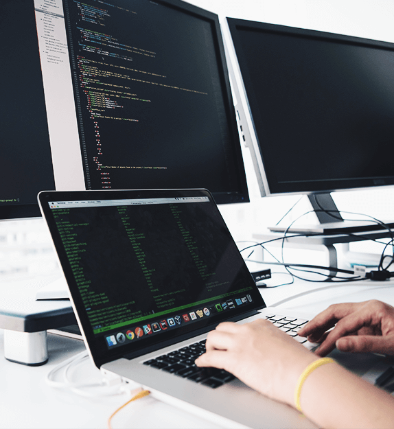 Person arbeitet an einem Laptop und schreibt Code