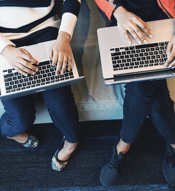 Zwei Personen die an einem Laptop arbeiten